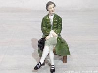 Front view of the Royal Doulton bone china figurine showing the gentleman seated with green coat, white stockings, and black buckle shoes.