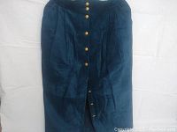 Full front view of the blue suede skirt with gold buttons and pleats