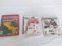 Three PlayStation 3 game cases shown: Resistance 2 Greatest Hits, NHL 10, and NHL 11 arranged side by side on white background.