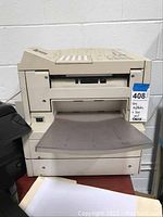 Front view of beige fax machine with paper tray and keypad visible
