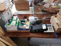 Omniview SOHO KVM switch, Logitech mice in boxes and Sony printer on desk, with cables and packing material.