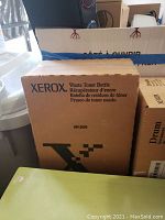 Photo showing Xerox branded waste toner bottle cardboard box and other packed items in background