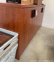 Side view showing wood grain and door handles of the wooden credenza.