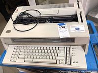 IBM Wheelwriter 3 Series II typewriter showing full view of keyboard and carriage with power cord on top.