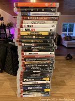 Photo showing a stack of 23 PS3 game cases including Lair, Oblivion, NHL, Call of Duty, Uncharted, Assassin's Creed and others.