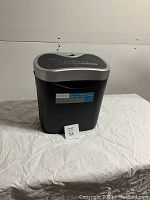 Front view of the black Omnitech paper shredder showing compact design and label on front.