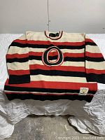 Front view of vintage striped hockey sweater with large 'O'