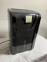 Front view of black Danby dehumidifier showing water collection tank and air intakes.
