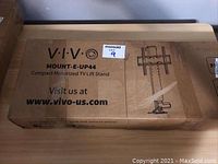 Closed box labeled VIVO MOUNT-E-UP44 with product info and illustration of stand.