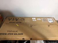 Open box of VIVO MOUNT-SF1FB black wall mounted folding workbench with branding and product details on the packaging.