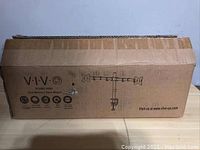 Closed cardboard box of VIVO Dual Monitor Mount Stand V002 with product illustration and brand name