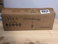 Closed cardboard box labeled VIVO STAND-V002 Dual Monitor Desk Mount showing brand, model, basic specs, and website link