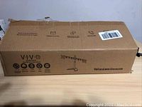 Closed box showing VIVO branding and model STAND-V002F on the packaging.