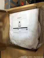 Photo showing the unopened white beekeeping jacket in original box packaging with product manual on top