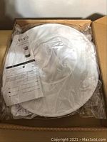 Photo showing the jacket and protective veil folded inside original sealed packaging with instruction sheet visible.