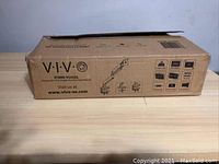 Photo of the cardboard box packaging showing VIVO brand, model STAND-V101G1 pneumatic single arm monitor desk mount with basic product illustration and brand website.