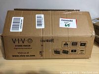 Closed box labeled VIVO STAND-V001M single monitor desk mount with shipping labels and MaxSold lot sticker.