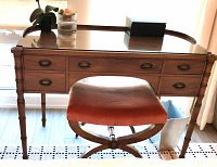 Full view of wood dressing table with glass top and matching stool