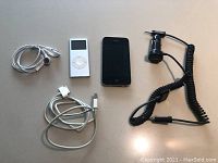 Photo showing iPhone 4, iPod Classic, car charger and stereo adapter with cables.