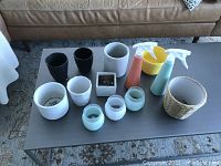 Photo showing all items including plant pots and two spray bottles on a coffee table.