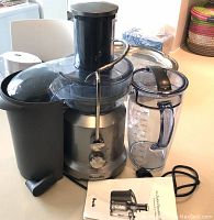 Main juicer assembled with pulp container, juice pitcher and power cord on countertop