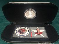 Black clamshell case opened showing silver medallion and pair of Canada Post NHL All-Stars stamps including image of Bobby Hull.