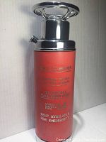 Full view of tall red cocktail shaker resembling a fire extinguisher with chrome lid and handle.