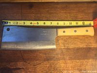 Full view of the cleaver alongside measuring tape showing approximate 12-inch blade length and wooden handle with three rivets.