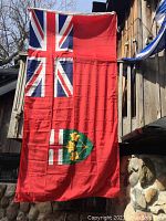 Ontario Provincial Flag hanging vertically showing full design with Union Jack and Ontario shield emblem.