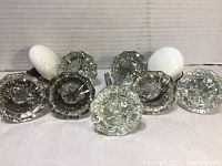 All the glass and porcelain door knobs arranged in front, showing clear faceted glass knobs and white porcelain ones.