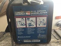 Photo showing full front label of sandblaster with usage instructions and branding.