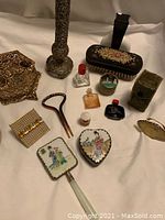 Full view of lot with assortment of vintage ladies grooming and accessory items including mini perfume bottles and hair pin.