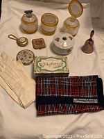 Full set overview including glass jars, gloves, compacts, box soap, scarf, hand bell, ceramic piece, and pendant