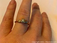 Engagement ring displayed on finger showing style and size.