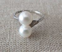 Front view of the vintage sterling silver ring with two round cultured pearls and raised silver detail on each side.