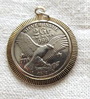 Front of the pendant showing detailed eagle design and markings.