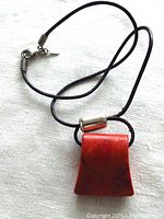 Front view of the necklace showing the sponge coral pendant suspended on a leather strand with silver clasp.