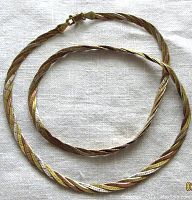 Full braided chain necklace laid flat showing length and tri-tone coloring.