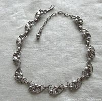 Full view of the vintage Bond Boyd sterling silver floral link necklace laid flat, showing front side detail and final clasp side with adjustable chain.