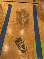 Top-down image showing clear crystal dreidel with handle and small Limoges porcelain dreidel box with lid open