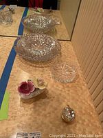 Photo of the crystal bowls and ashtrays arranged on wood surface including the bone china bouquet