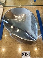 Top view of the polished, asymmetrical Nambe metal bowl showing reflective surface and scratches.