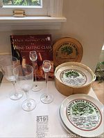 Photo showing two Lalique champagne flutes, two Rosenthal crystal stemware glasses, a wine tasting class book, and crudités plates partially boxed and displayed on a table.