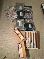 Several binders and boxes filled with sports trading cards laid out on a carpet.