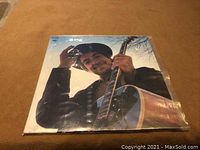 Front cover of Bob Dylan "Nashville Skyline" LP featuring artist smiling with guitar, wearing a hat.