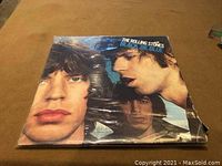 Front cover of The Rolling Stones Black and Blue album sleeve showing close-up of band members' faces.