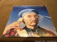 Front cover of Holger Czukay LP album titled 'Der Osten Ist Rot' showing a close-up portrait of Holger Czukay with coiled wire.