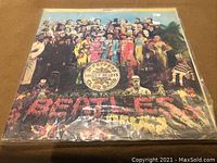 Front cover of The Beatles Sgt. Pepper's Lonely Hearts Club Band vinyl LP showing iconic colorful group image with the band name and album title.