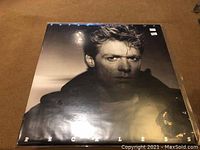 Front cover of the Bryan Adams Reckless album showing a close-up black and white portrait of Bryan Adams with the album title and artist name