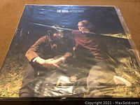 Front cover of The Sufis LP "Inventors" showing two men sitting outdoors on grass.